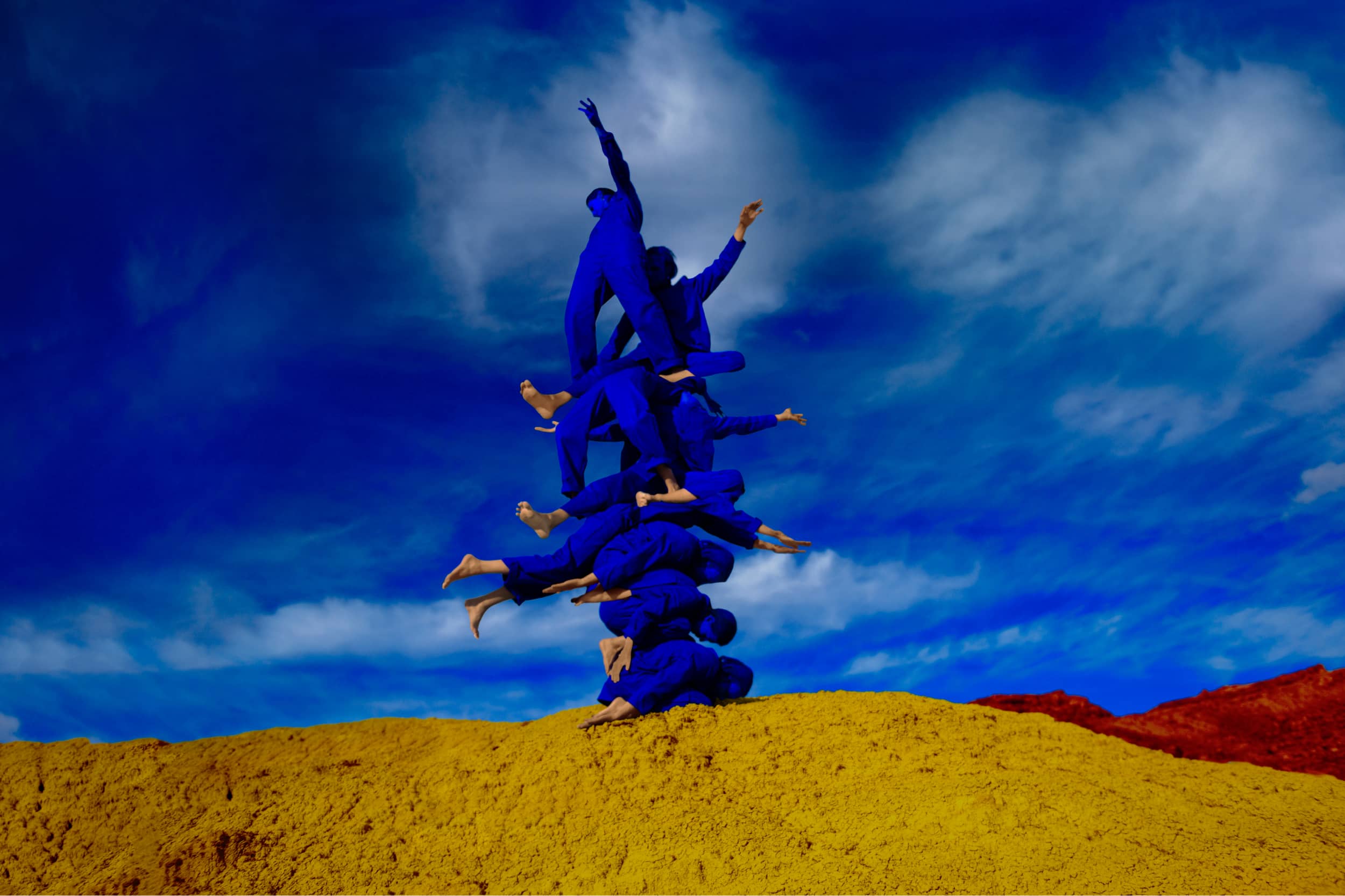 Interconnected figures stand resilient under a vast sky. This image depicts the strength of unity, diversity, optimism and the shared vision of building a brighter future.